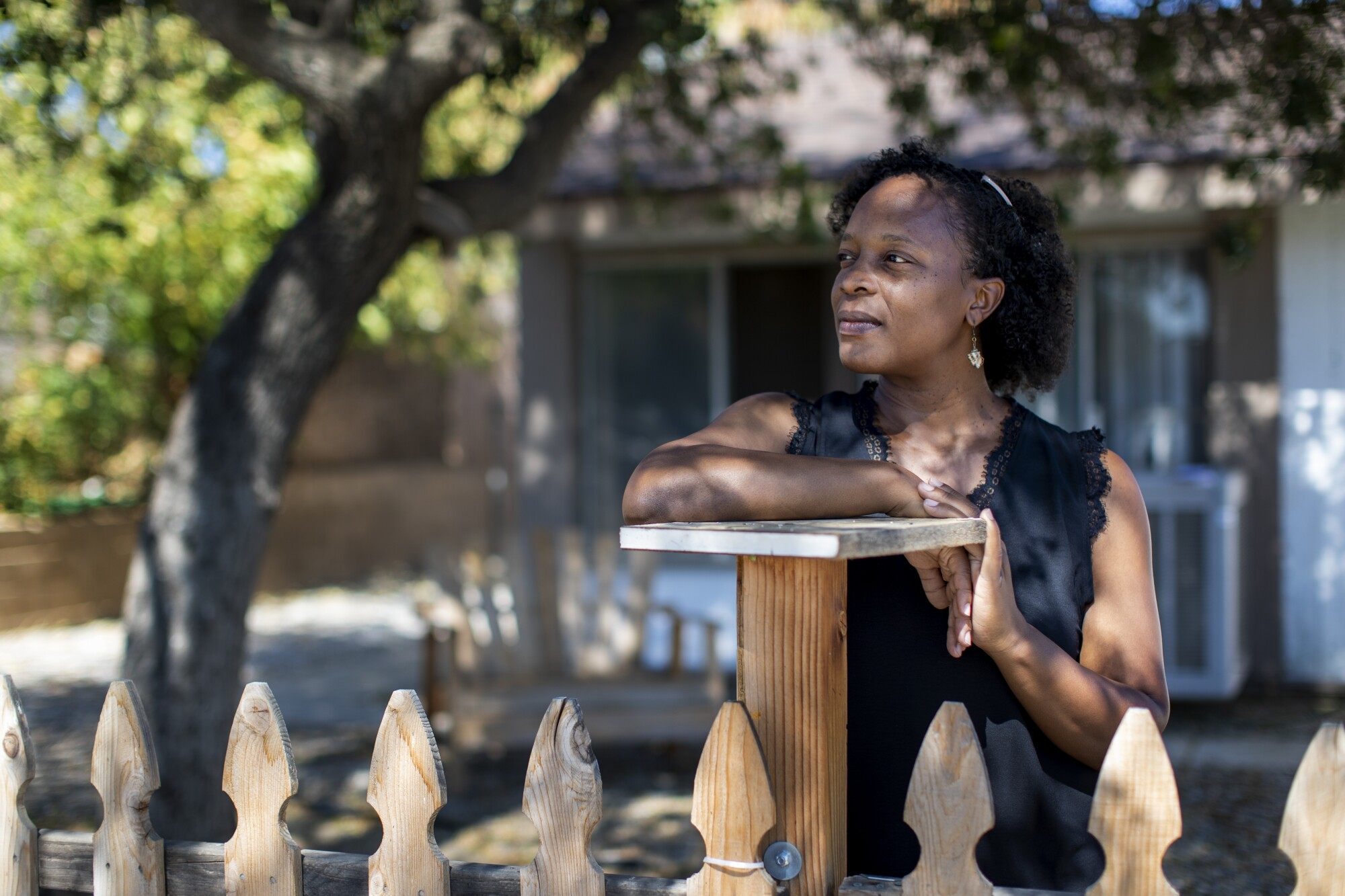 Fatima Nelson stands near a shade tree outside at her home in Moreno Valley.