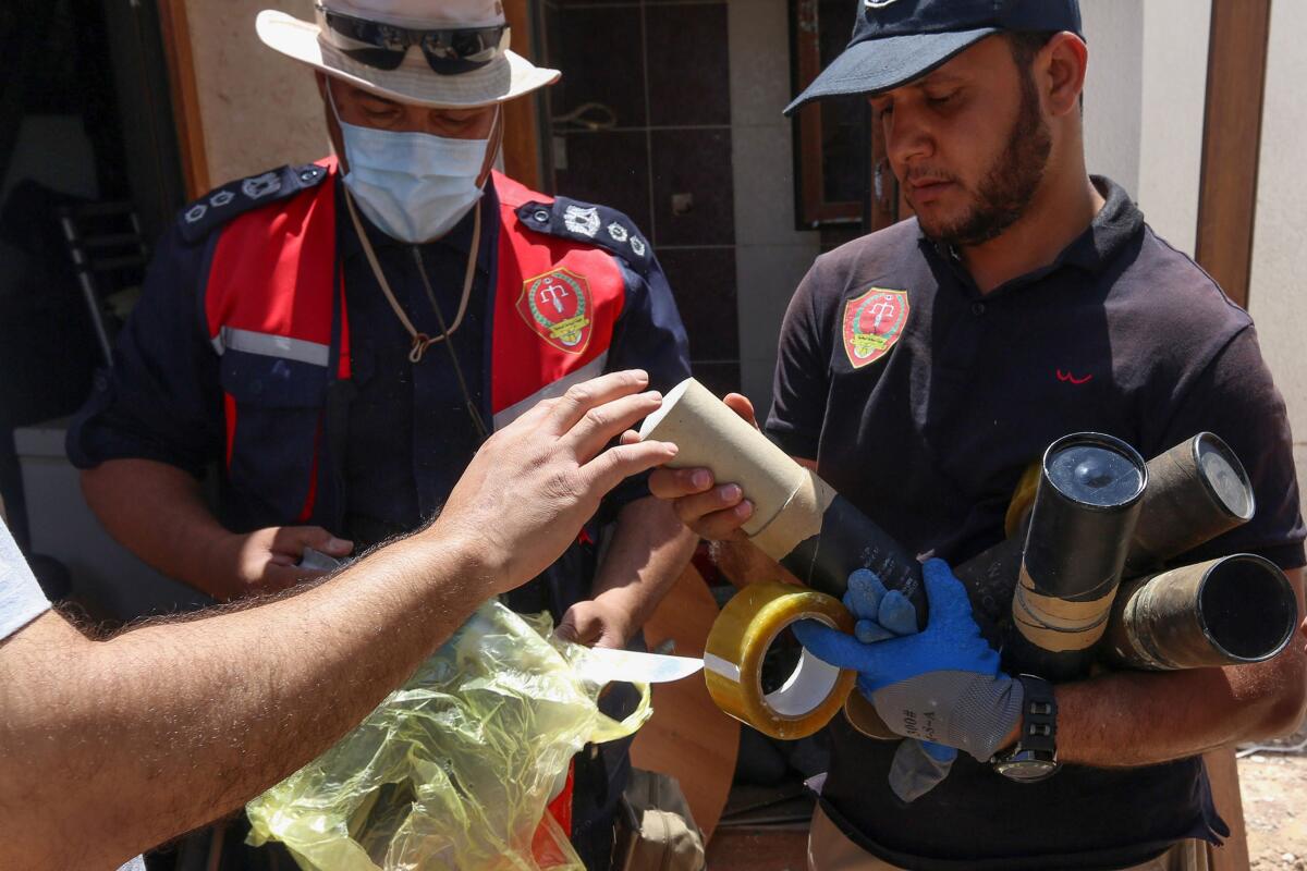 Libyan deminers collect exploded mortar shells found in a suburb of Tripoli.