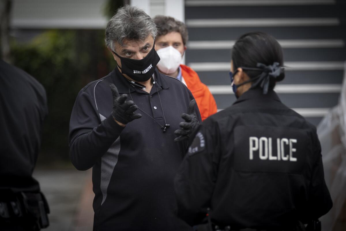 Ferris Wehbe, a member of the Central Hollywood Neighborhood Council, talks to LAPD Officer Kat Piamonte while delivering food in Hollywood on Thursday.