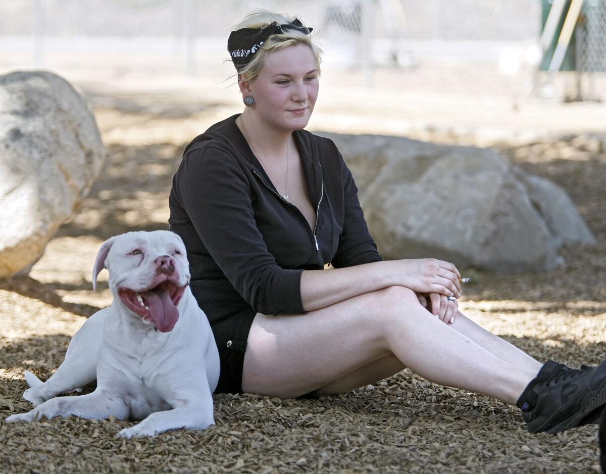 Chandra Tamraz, 19 of Sunland, and her dog Kilo rest in the shade at the Crescenta Valley Dog Park as temperatures reached the century mark in La Crescenta on Thursday, August 29, 2013. Temperatures will remain hot through the weekend.