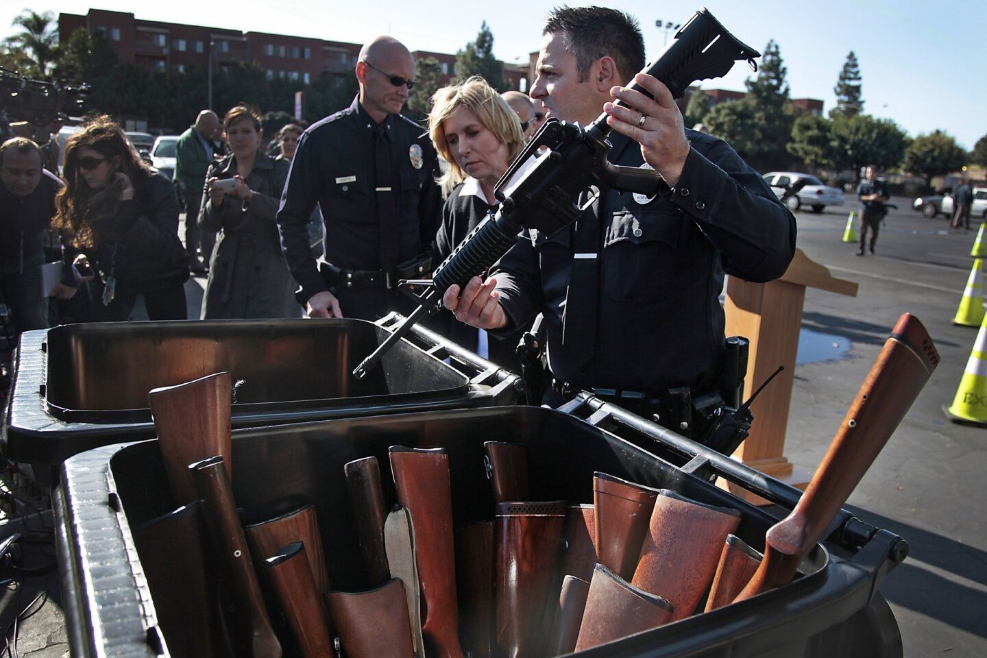 LAPD reserve officer Joe Buscaino, who is also a Los Angeles city council member, holds an assault weapon that was turned in.