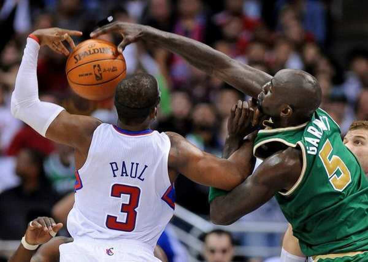 Clippers point guard Chris Paul and Celtics power forward Kevin Garnett battle for a rebound during a game last season at Staples Center.