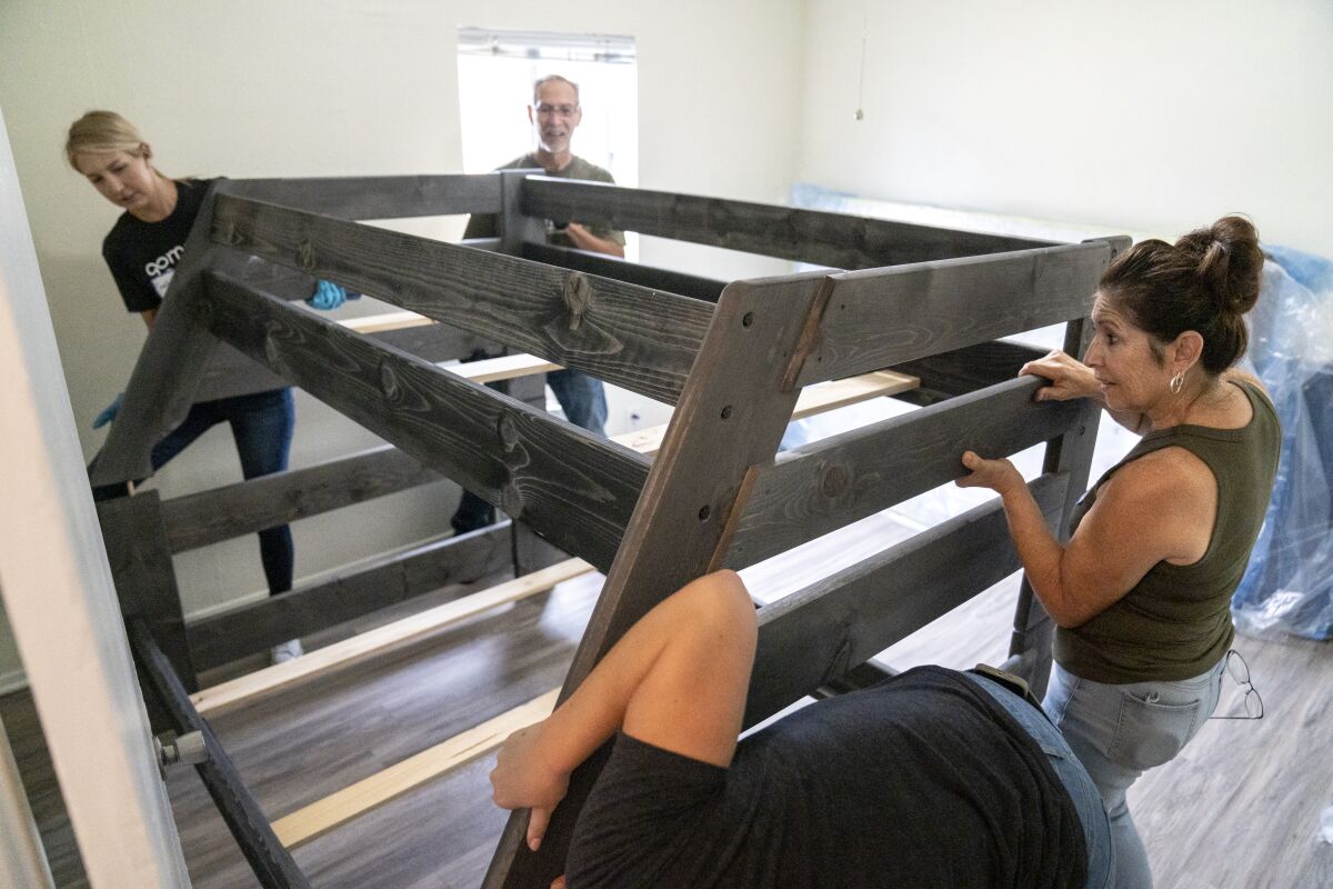 Volunteers help build a bunk bed donated to Solutions for Change on Friday.
