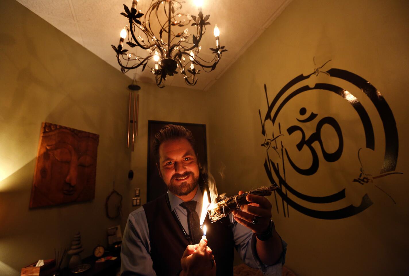 Dr. Michael Lewis of Willow Healing Center burns native white sage inside his office in Woodland Hills.