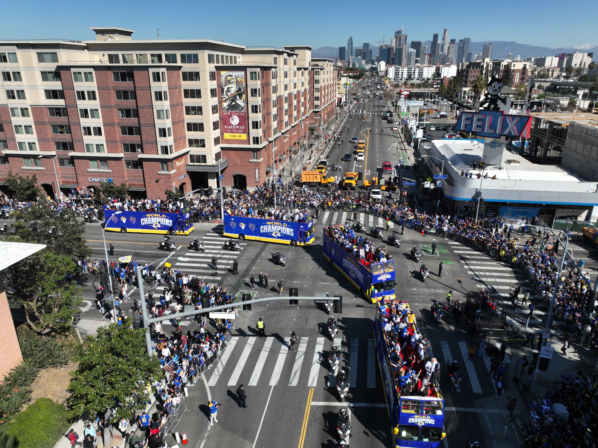 Buses carrying Rams players, coaches and their families head to Exposition Park during the Super Bowl parade.