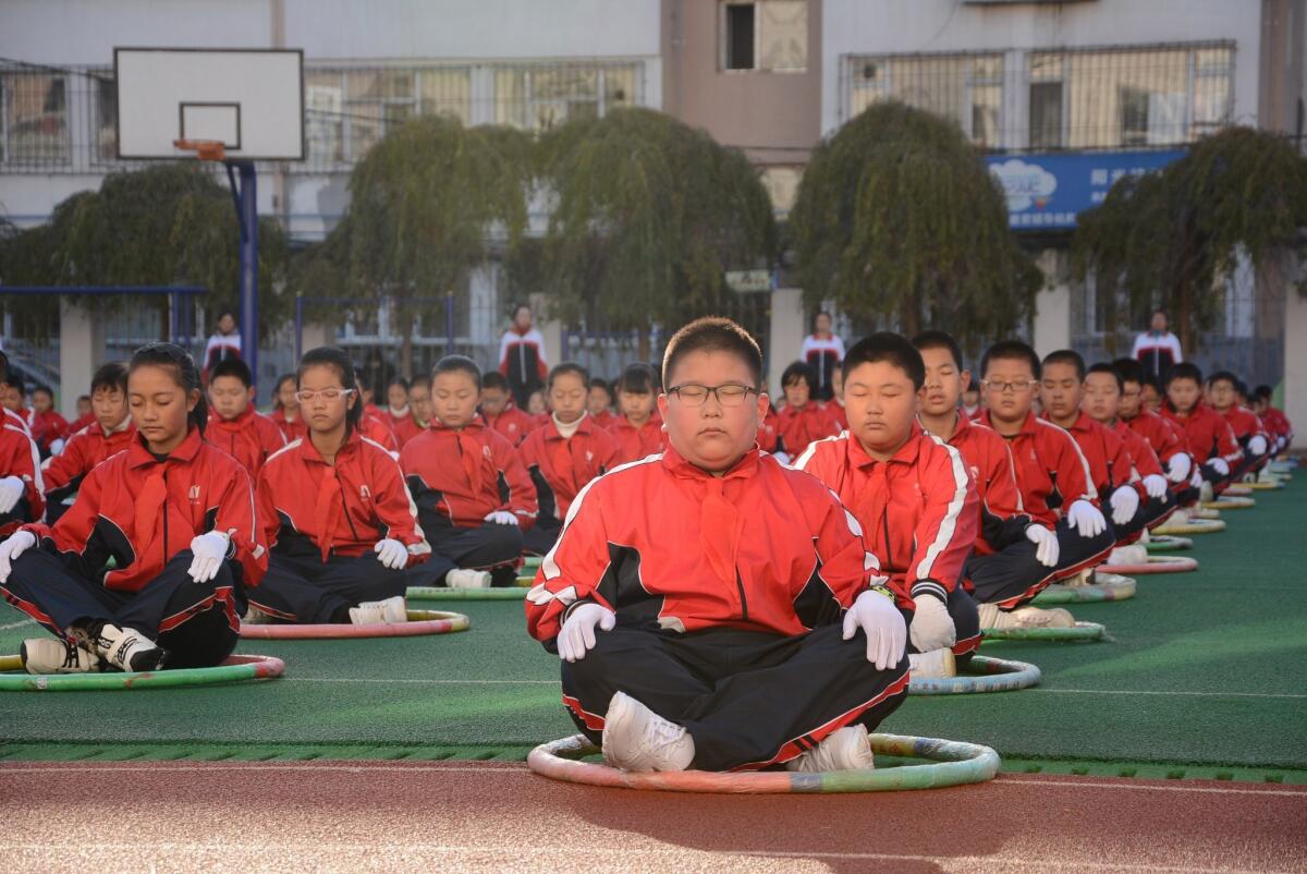 This photo taken Tuesday shows pupils exercising on the playground during a break at an elementary school in Jilin, in northeast China's Jilin province.
