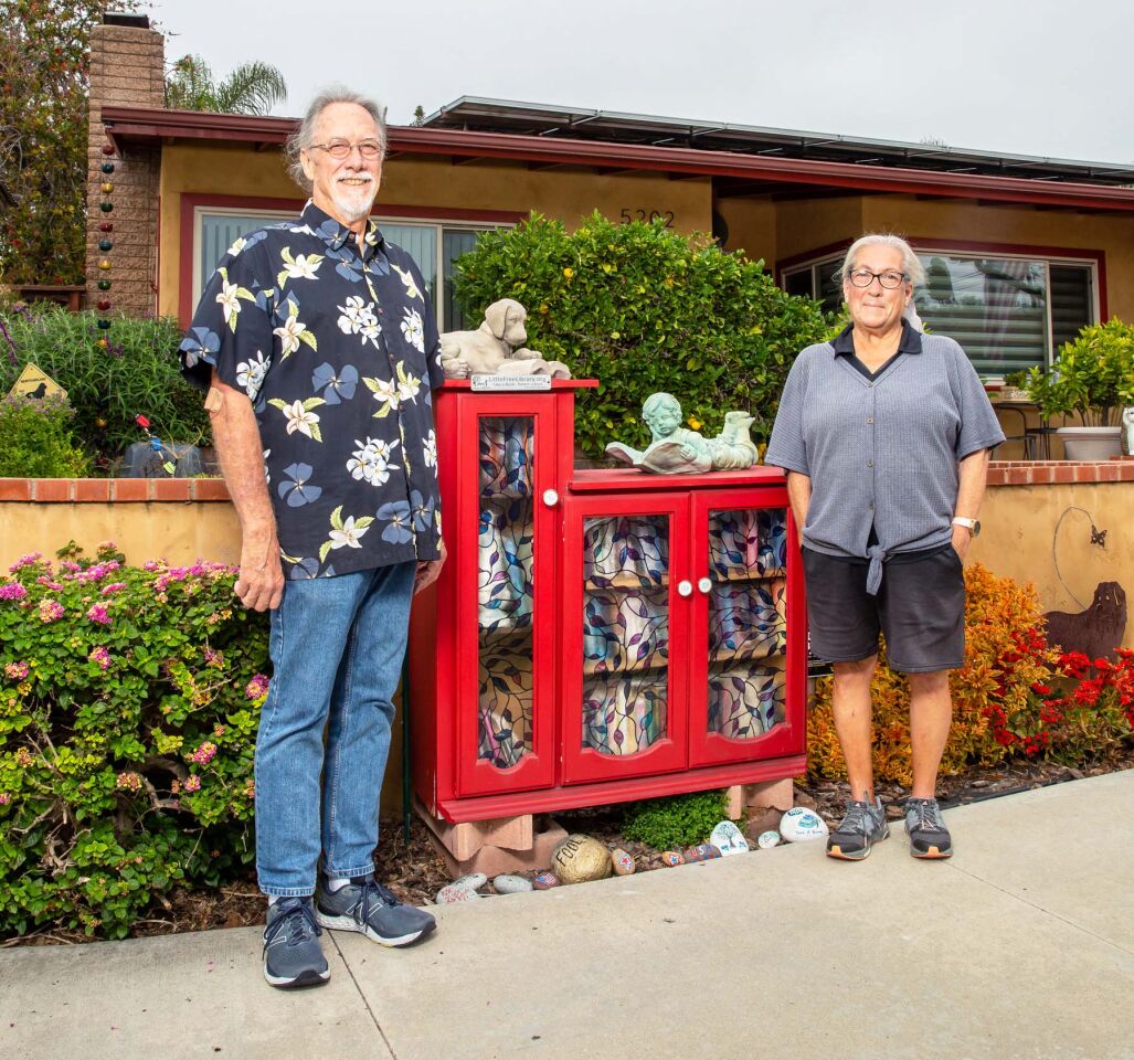 Jim Moore and Roseann Vecchio with their Little Free Library at 5202 Vickie Drive.