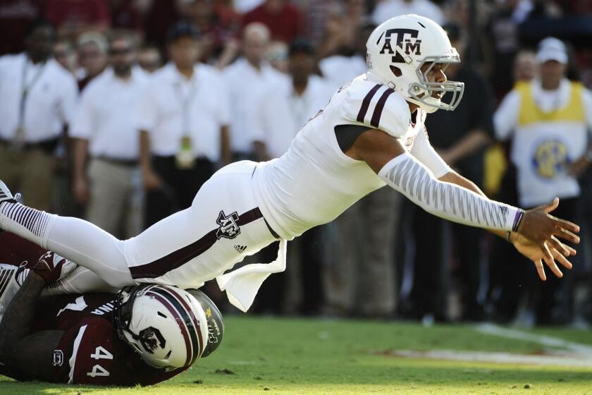 Texas A&M quarterback Kenny Hill throws a shovel pass as South Carolina defensive end Gerald Dixon pulls him down during the first half of a game Thursday at Williams-Brice Stadium in Columbia, S.C.