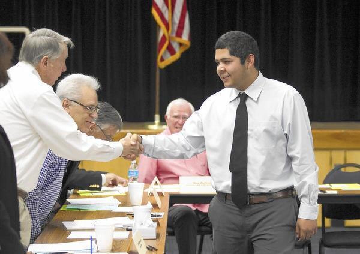 Back Bay senior Brijan Ochoa-Sanchez shakes hands with one of the interviewers, Phil Reynolds, at Back Bay High School on Friday.