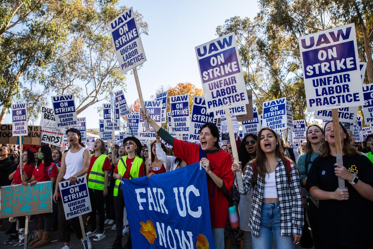 UC San Diego workers hold signs reading "UAW On Strike" and "Fair UC Now."