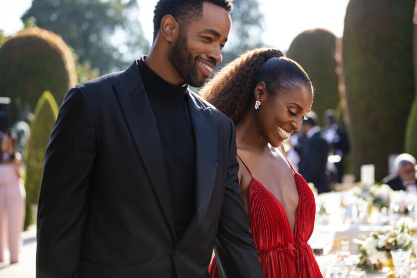 A man in a suit and a woman in a red dress