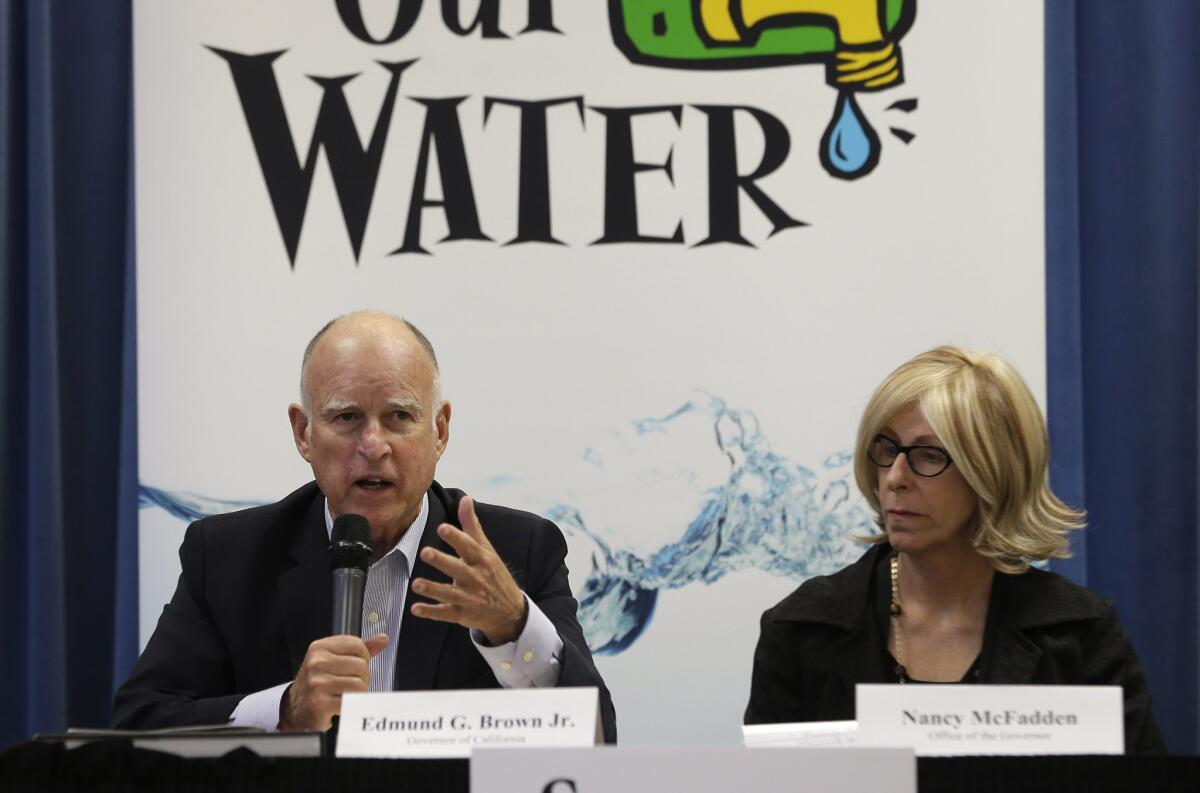 Gov. Jerry Brown, with Executive Secretary Nancy McFadden, talks to reporters at the end of a meeting on the drought last week.