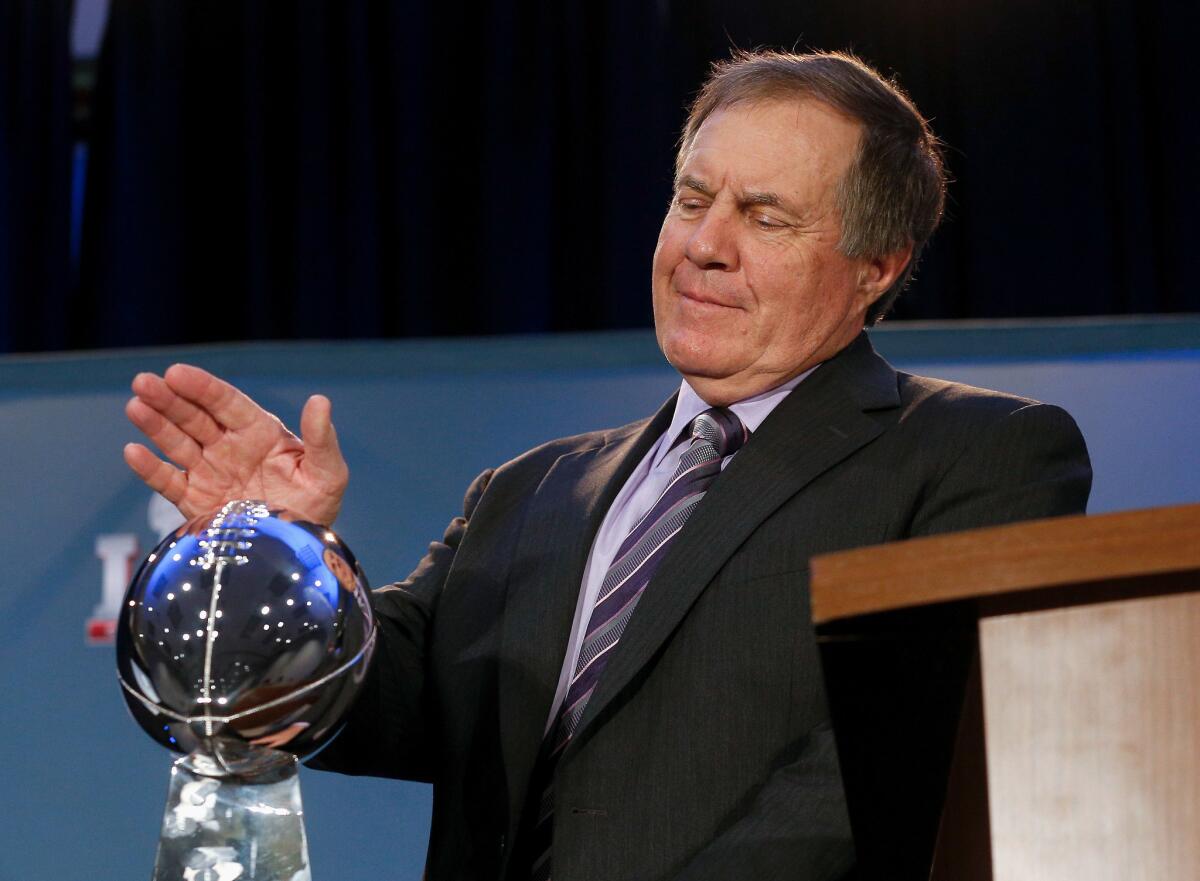 New England Patriots Coach Bill Belichick pats the Vince Lombardi trophy during a news conference on Monday in Houston.