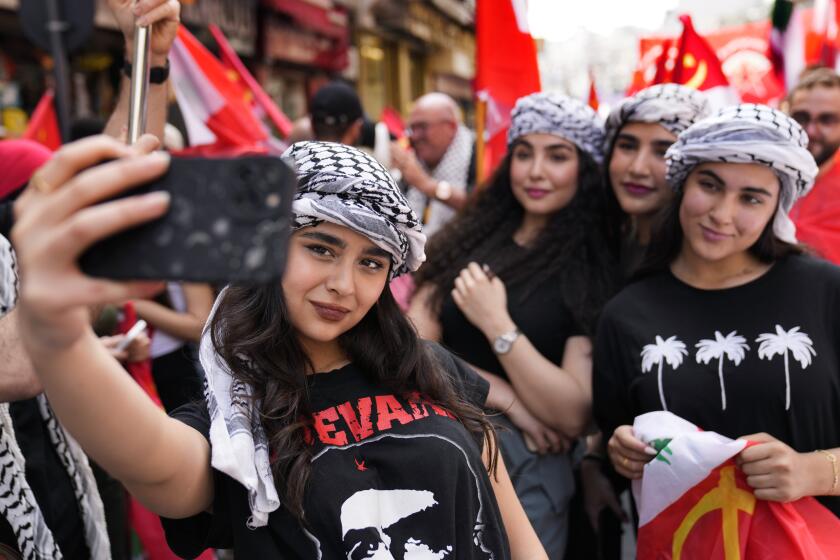 Supporters of the Lebanese Communist party take a selfie, as they march during a demonstration to mark International Labor Day or May Day, in Beirut, Wednesday, May 1, 2024. Despite the tense situation and ongoing clashes on Lebanon's border with Israel over the past seven months, hundreds of protesters marched through Beirut's streets to mark International Workers' Day. (AP Photo/Hussein Malla)