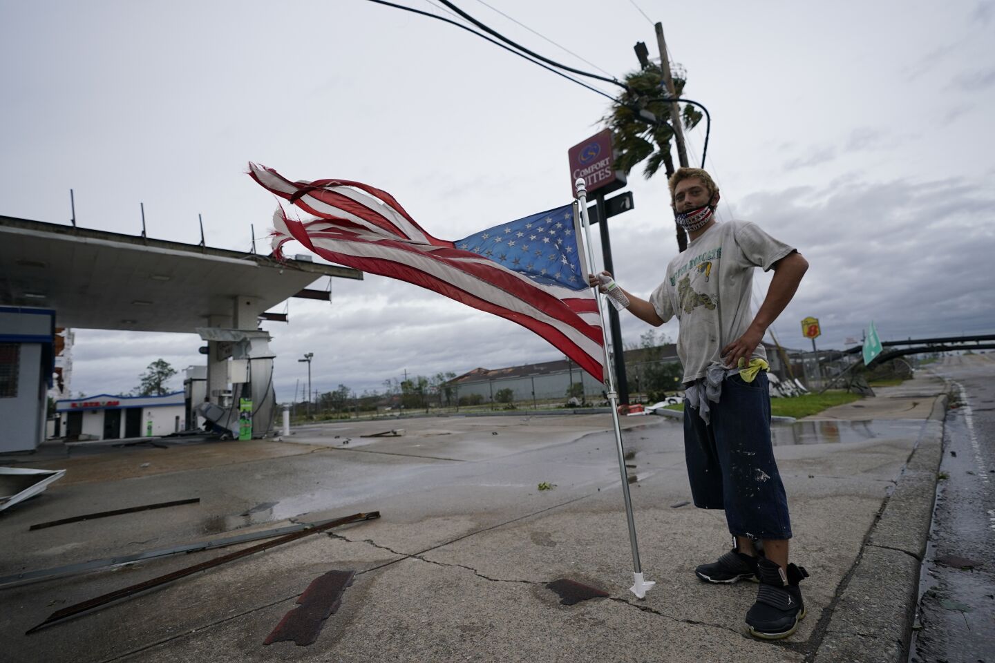 Dustin Amos looks at damage to a gas station in Lake Charles, La.