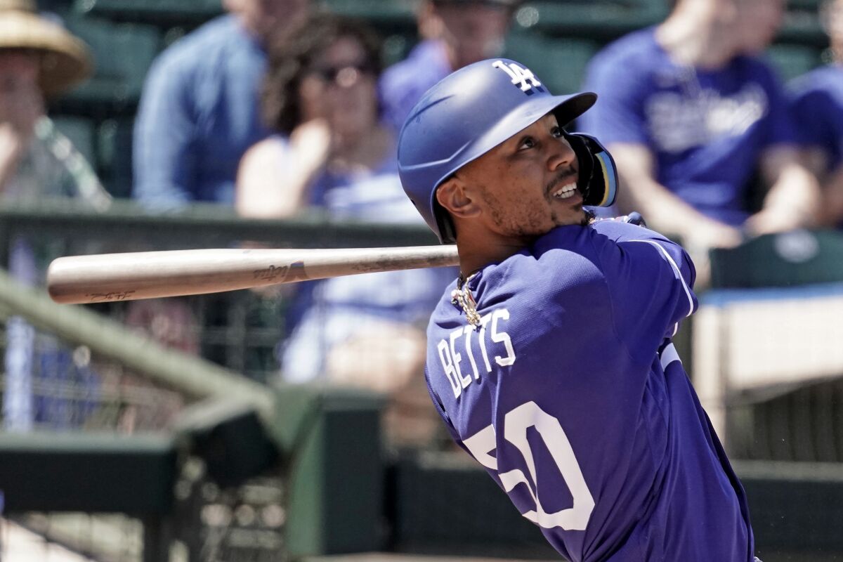 Los Angeles Dodgers' Mookie Betts bats during the first inning of a spring training baseball game against the Texas Rangers
