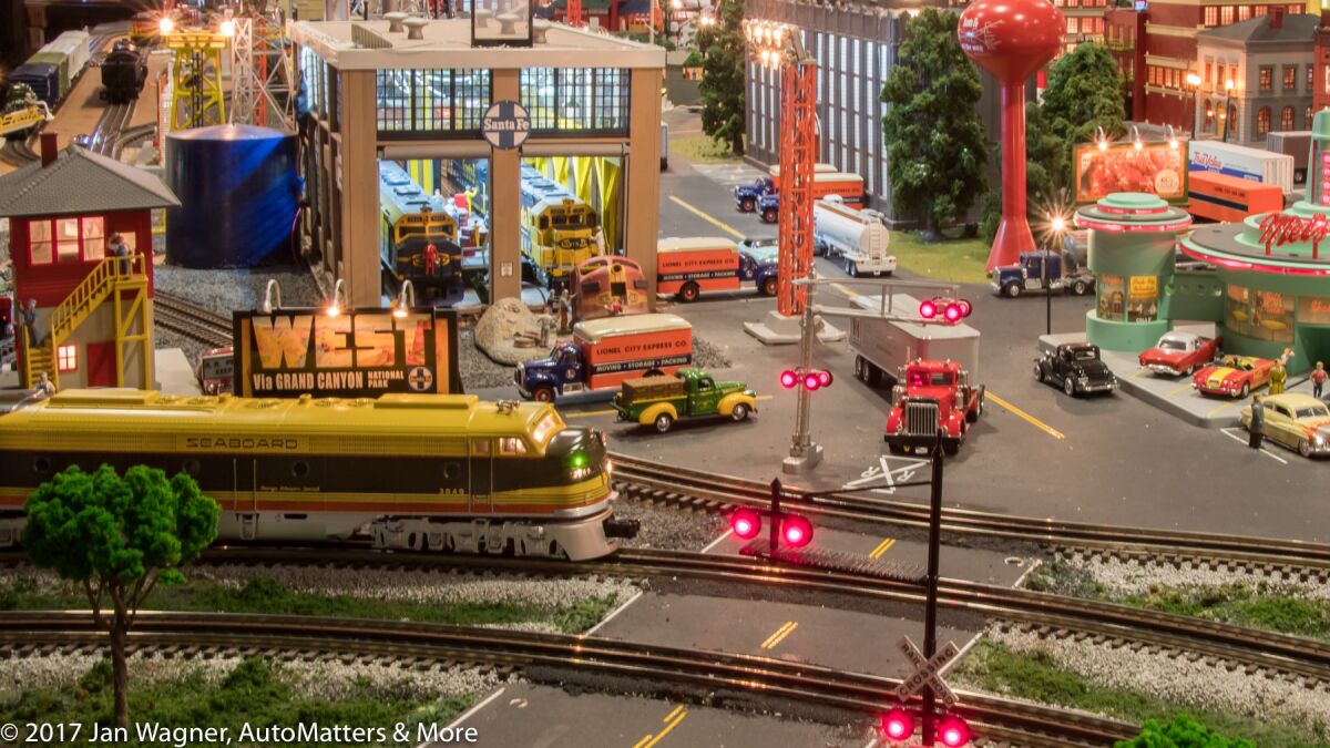 Scale model train approaching a railway crossing