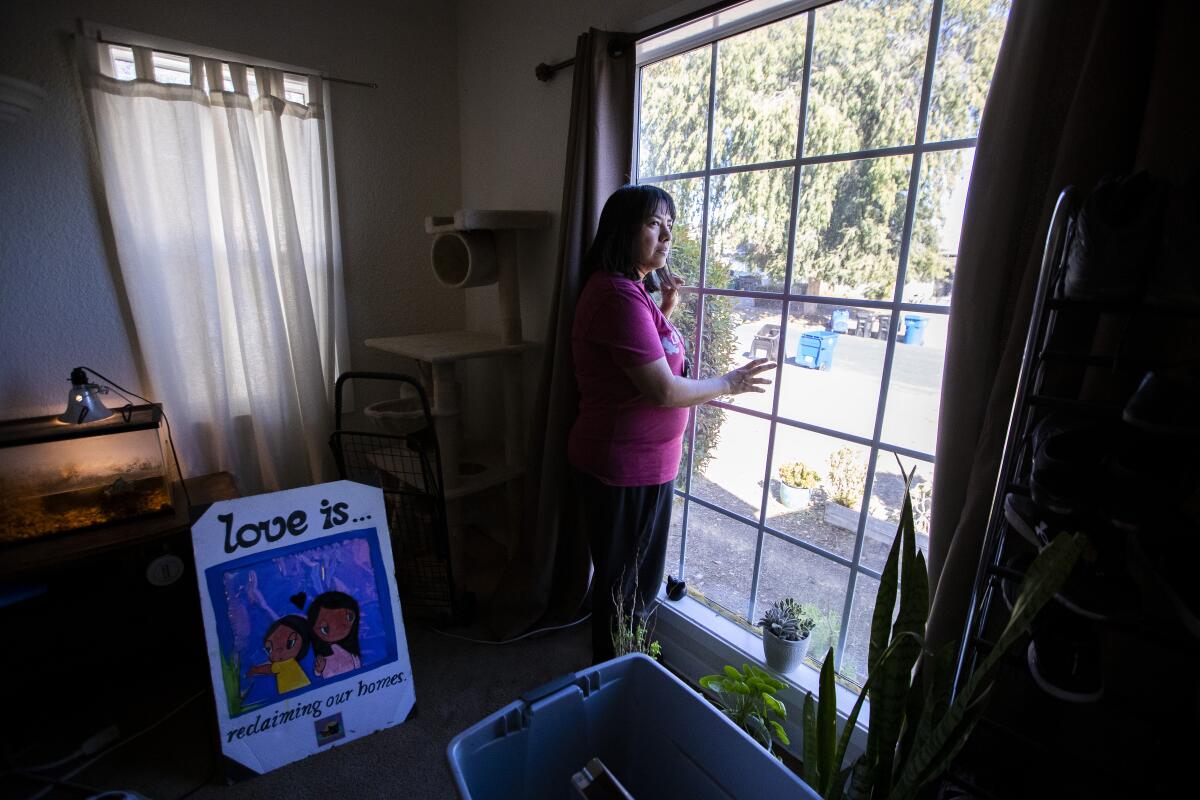 A woman looks out a window