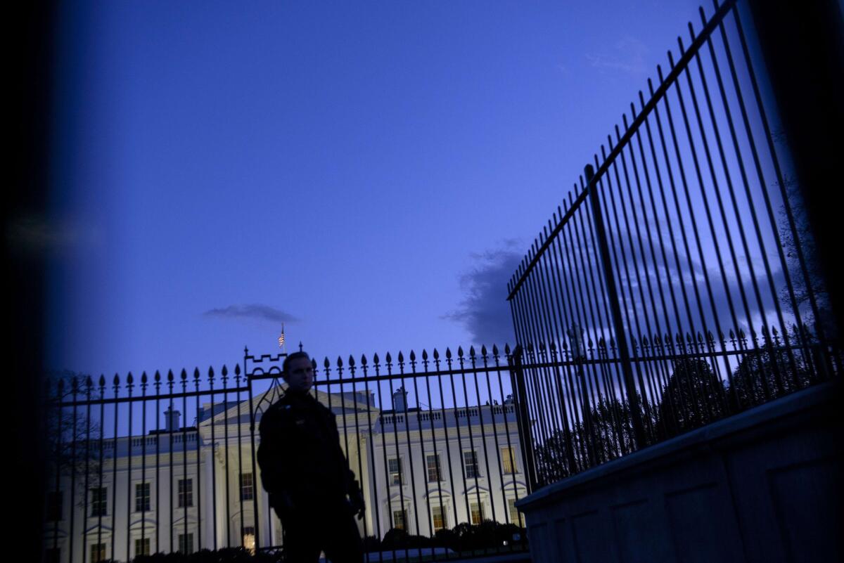 A member of the Secret Service patrols outside the White House.