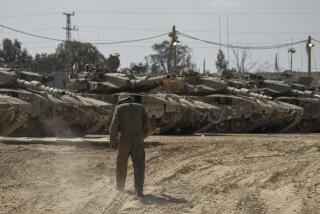 Israeli soldiers work on tanks at a staging ground near the border with the Gaza Strip, in southern Israel, Thursday, April 11, 2024. (AP Photo/Tsafrir Abayov)