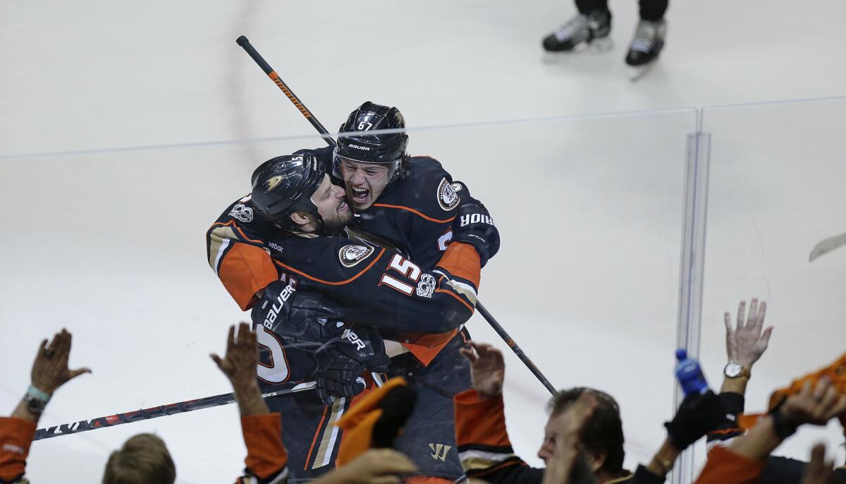 Ducks center Rickard Rakell (67) celebrates with teammate Ryan Getzlaf (15) after scoring the tying goal with 15 seconds left in the third period Friday.