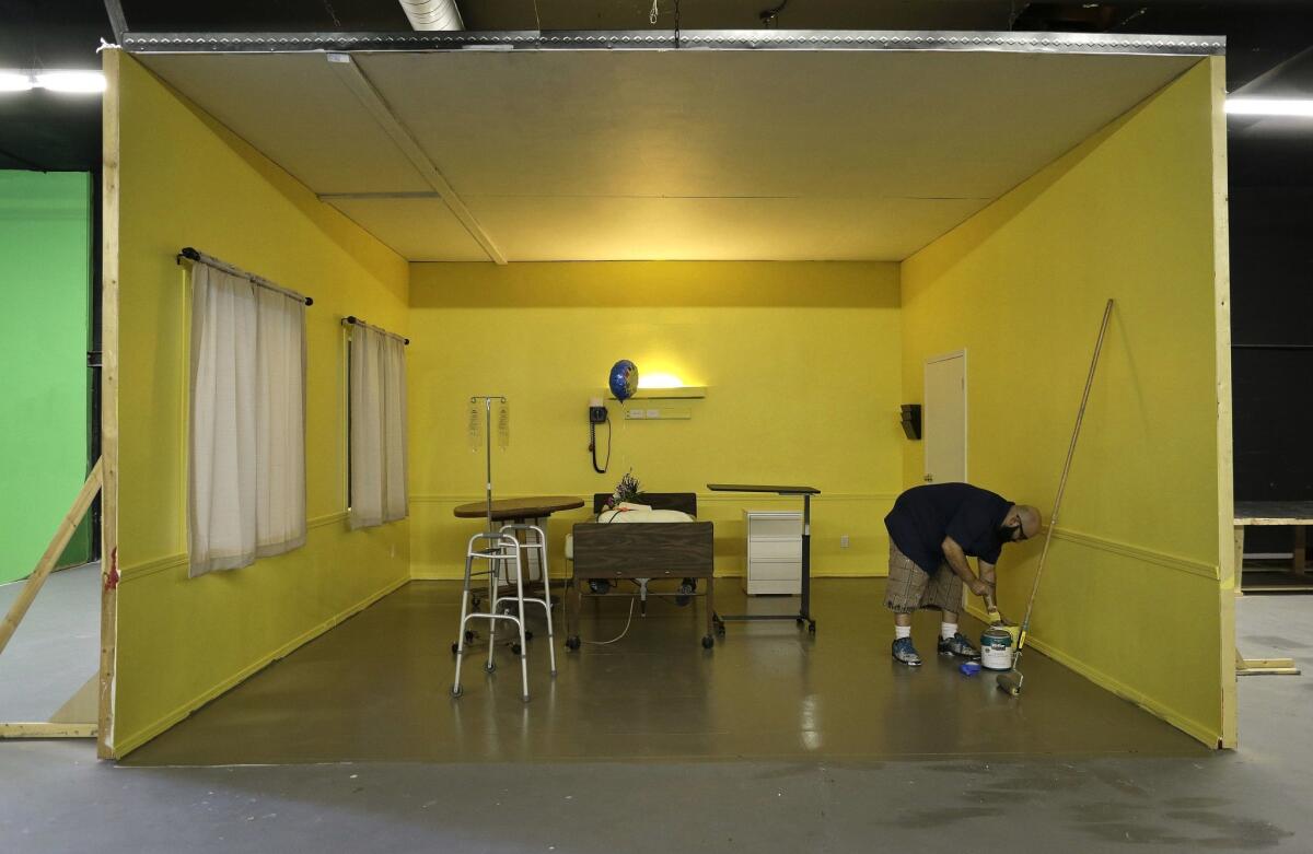 Studio owner and adult film film director Lee Roy Myers prepares paint while working on a hospital room set at his studio, Mission Control Studios in Las Vegas.