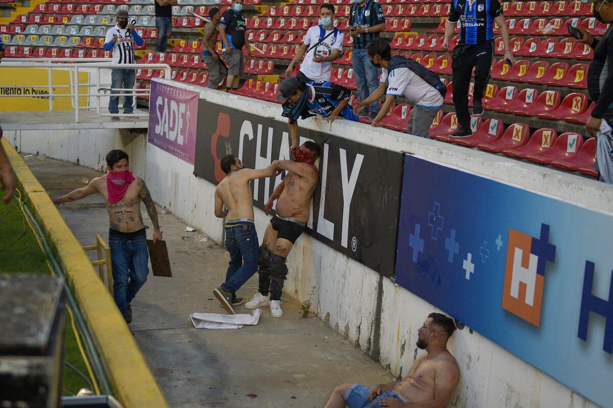 Aficionados del Querétaro y del Atlas riñen durante un partido de la Liga MX,
