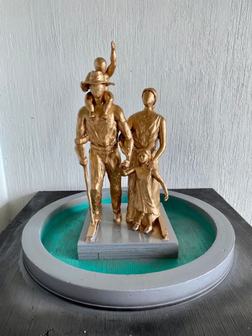 A scale model of a bronze sculpture of a railroad worker and his family