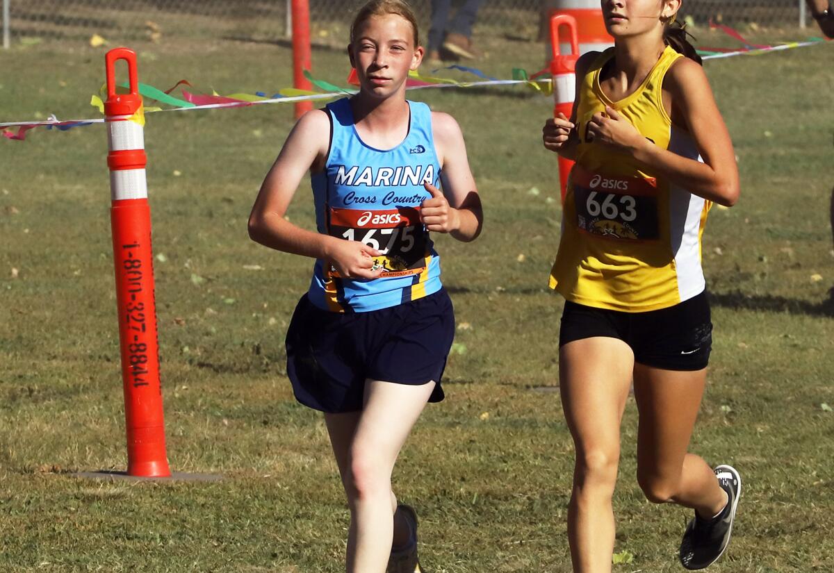 Marina's Sally Woodruff, left, competes in the Orange County cross-country championships at Oak Canyon Park on Saturday.