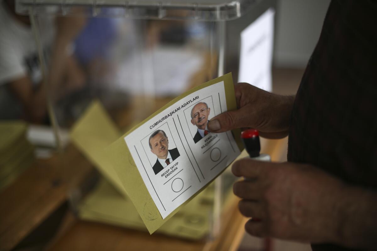 A man holds a ballot with the names and images of Recep Tayyip Erdogan and Kemal Kilicdaroglu,