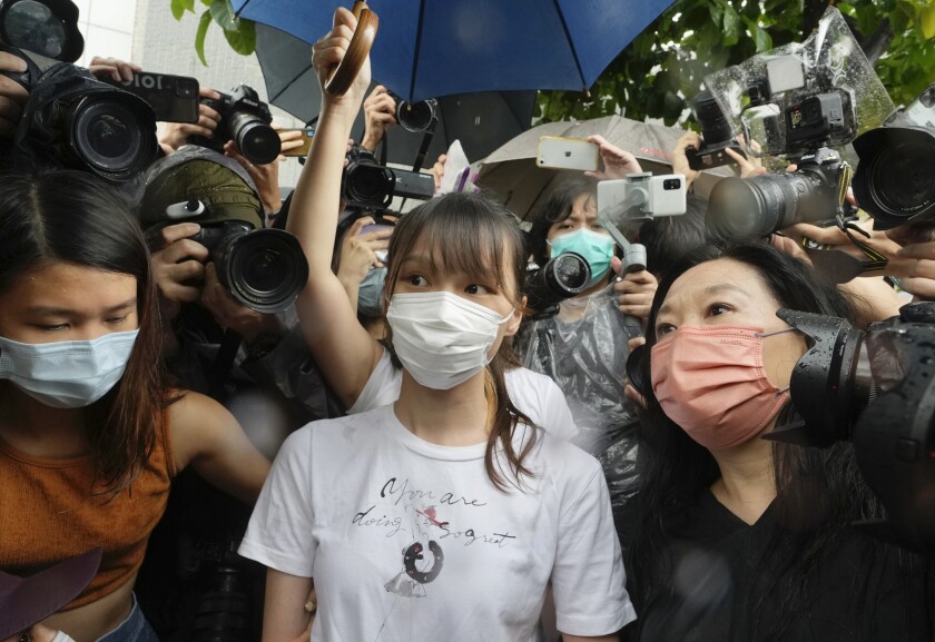 Agnes Chow, center, a prominent pro-democracy activist who was sentenced to jail last year for her role in an unauthorized protest, is released in Hong Kong Saturday, June 12, 2021. Chow rose to prominence as a student leader in the now defunct Scholarism and Demosisto political groups, alongside other outspoken activists such as Joshua Wong and Ivan Lam. (AP Photo/Vincent Yu)