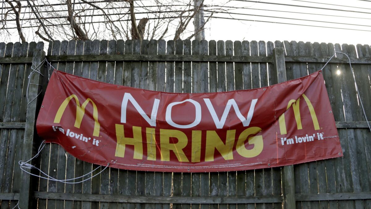 An employment sign hangs from a wooden fence on the property of a McDonald's restaurant in Atlantic Highlands, N.J.