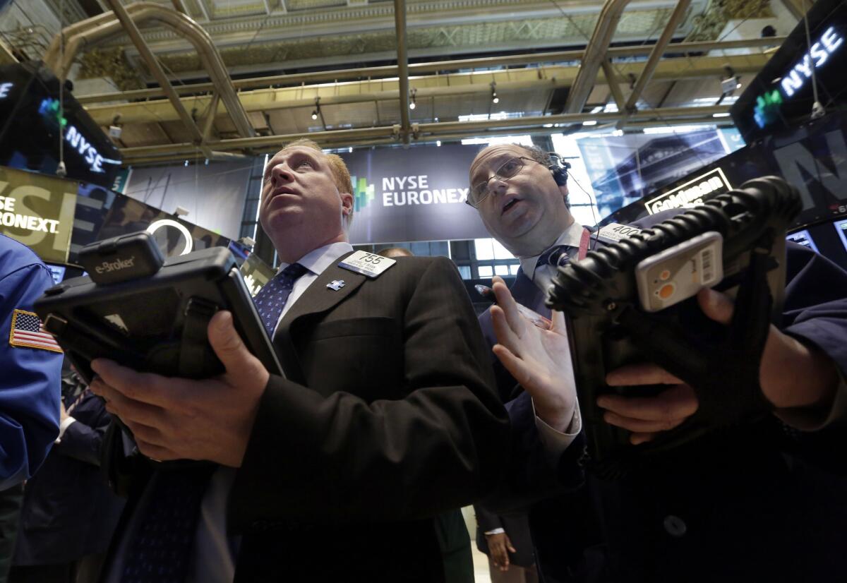 Traders Dan Ryan, left, and Gordon Charlop work on the floor of the New York Stock Exchange Tuesday.