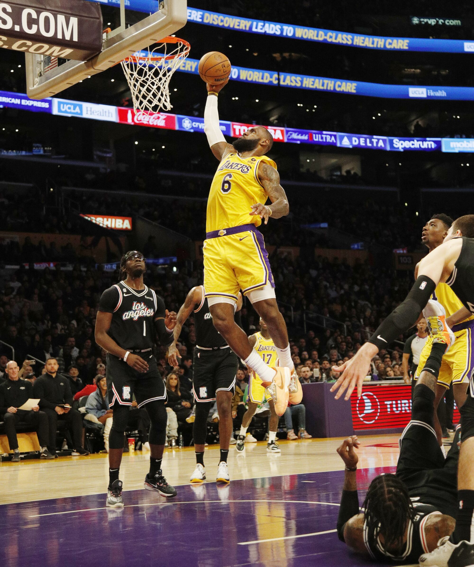 Lakers forward LeBron James (6) soars for a slam dunk against the Clippers.