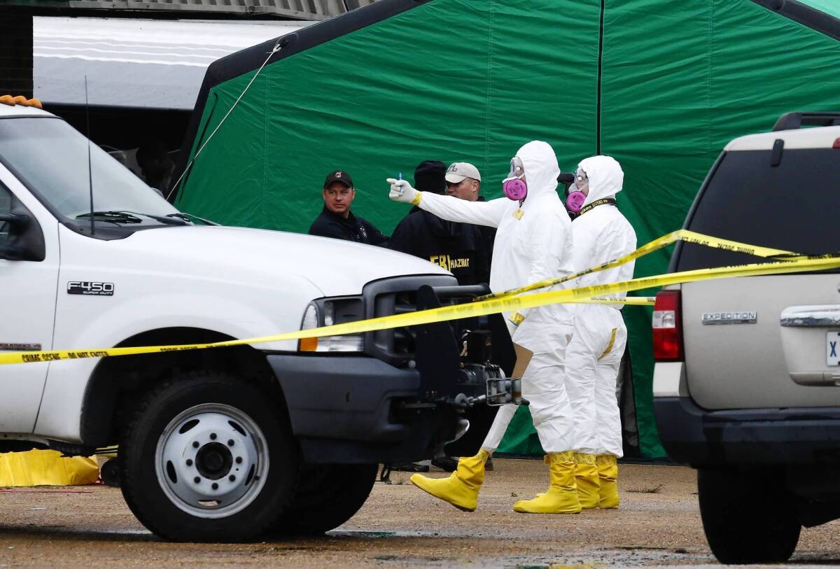 Federal investigators in protective suits gather outside a Tupelo, Miss., business space where James Everett Dutschke is said to have operated a martial arts studio. Authorities are investigating the site in connection with the ricin case, but Dutschke has not been arrested or charged.