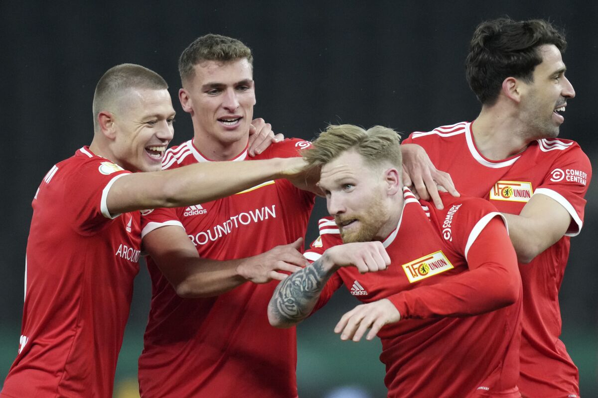 Union's Andreas Voglsammer, 2nd right, celebrates with teammates after scoring his sides first goal during the German Soccer Cup round of 16 soccer match between Hertha BSC Berlin and 1 FC Union Berlin at the Olympic Stadium in Berlin, Germany, Wednesday, Jan. 19, 2022. (AP Photo/Michael Sohn)