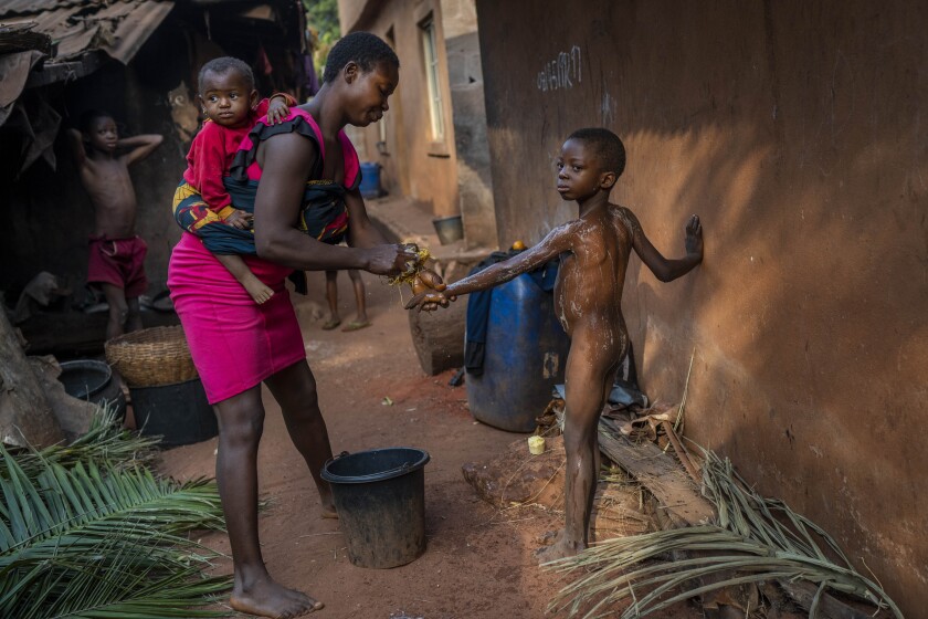 Anayo Mbah baña a sus hijos en su modesta vivienda de Umuida (Nigeria) el 12 de febrero del 2022. (
