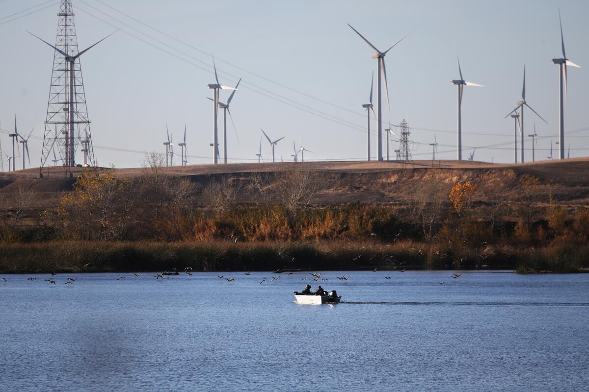 Wind turbines and boaters along the Sacramento River.