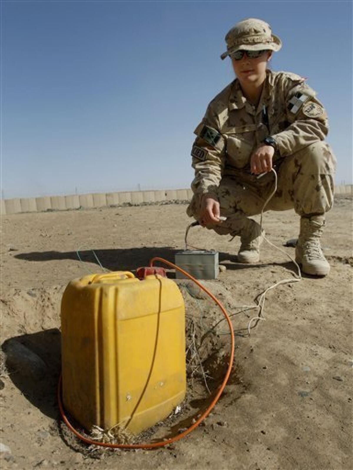 Lt. Caroline Pollock from Calgary, Alberta of the Canadian Counter Improvised Explosive Device Squadron (CIED), is seen as she sets up an IED for training purposes at Camp Hero in Kandahar, southern Afghanistan, Monday, Feb. 1, 2010. (AP Photo/Kirsty Wigglesworth)