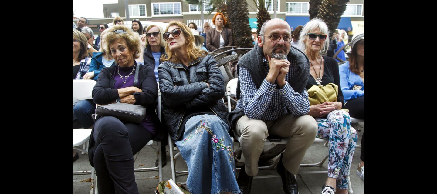 People sit outside at D.G. Wills Books in La Jolla on Saturday as they listen to actor Sean Penn, who is inside, talk about his book 'Bob Honey Who Just Do Stuff' over a speaker system.