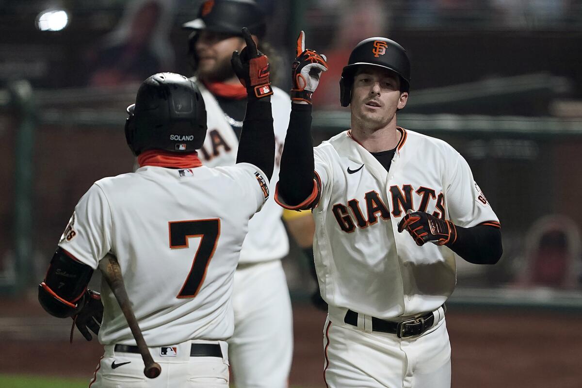 San Francisco Giants' Mike Yastrzemski, right, gestures with teammate Donovan Solano after hitting a three-run home run