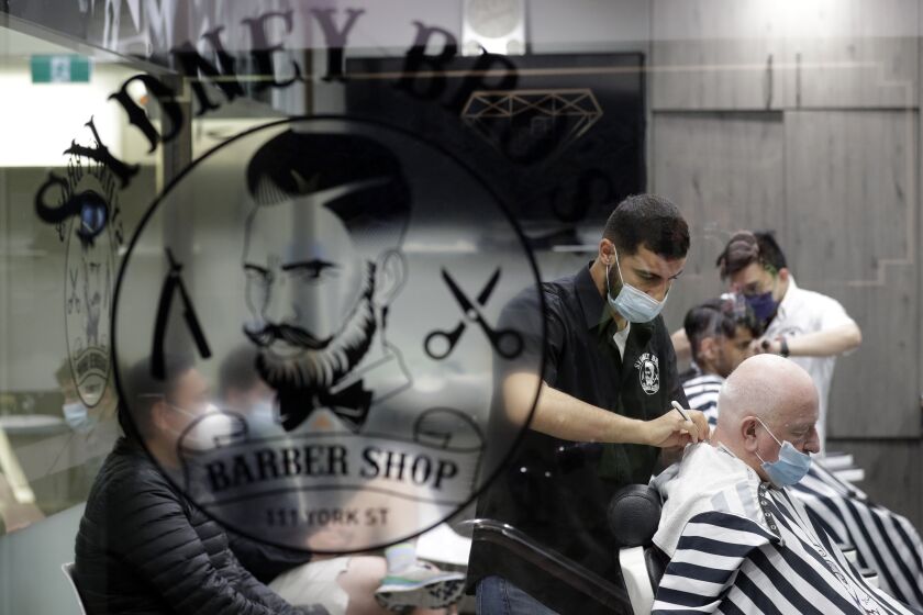 A barber shop clips and snips some of their first costumers in months after more than 100 days of lockdown to help contain the COVID-19 outbreak in Sydney, Monday, Oct. 11, 2021. (AP Photo/Rick Rycroft)