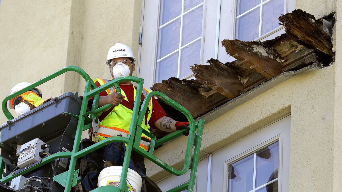 A crew works on the remaining wood of an apartment building balcony that collapsed in Berkeley in 2015.