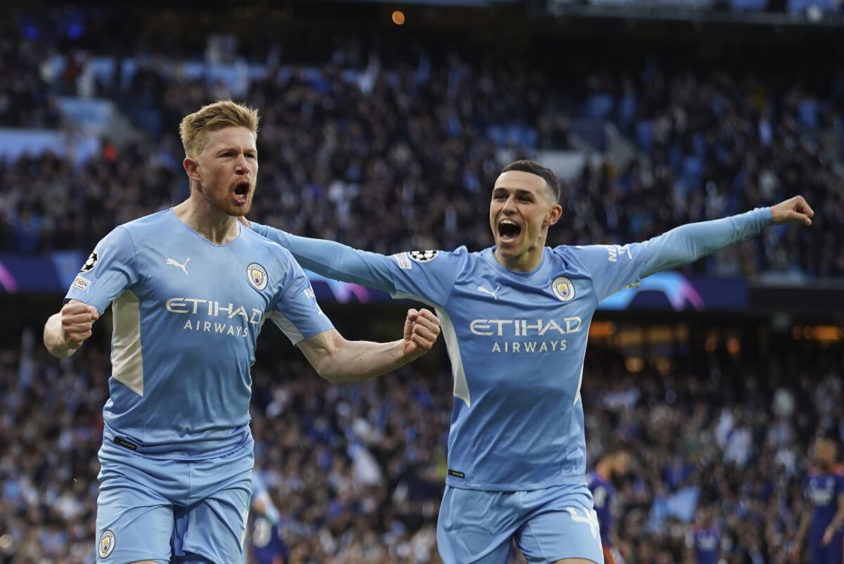Manchester City's Kevin De Bruyne, left, celebrates after scoring his side's opening goal during the Champions League semi final, first leg soccer match between Manchester City and Real Madrid at the Etihad stadium in Manchester, England, Tuesday, April 26, 2022. (AP Photo/Dave Thompson)