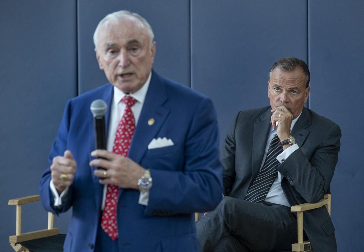 Former LAPD chief William Bratton speaks as Rick Caruso sits behind