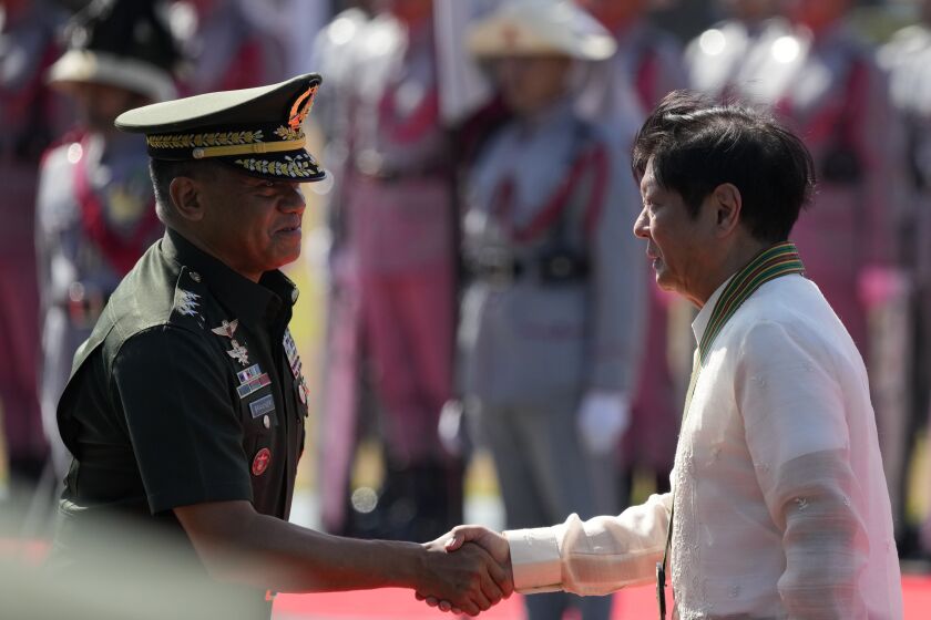 Philippine President Ferdinand Marcos Jr., right, shakes hands with Philippine Army Commanding General Lt. Gen. Romeo Brawner Jr. during rites at the 126th founding anniversary of the Philippine Army at Fort Bonifacio in Taguig, Philippines on Wednesday, March 22, 2023. (AP Photo/Aaron Favila)