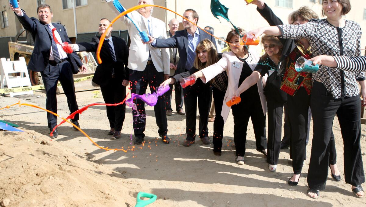 City of Glendale, local politician reps, contractors and YMCA officials throw paint onto a mound of dirt near the construstruction site for the new Glendale Arts Colony being built on the Y's campus in Glendale on Wednesday, Feb. 18, 2015. The $30 million, 70-unit willopen in 2016.