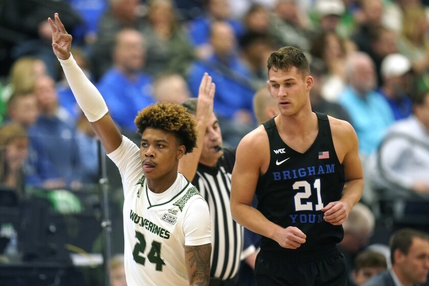 Utah Valley guard Justin Harmon (24) celebrates after scoring a 3-pointer as BYU guard Trevin Knell (21) looks on in the first half during an NCAA college basketball game Wednesday, Dec. 1, 2021, in Orem, Utah. (AP Photo/Rick Bowmer)