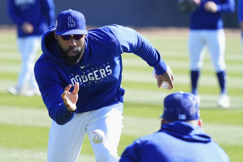 Los Angeles Dodgers outfielder Jason Heyward reaches for the ball during outfielder drills.