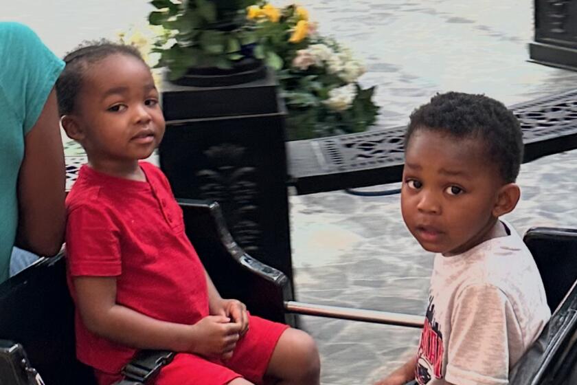 Twin brothers Jestine "Juju" James (left) and Josiah "Jojo" James on a ride at the mall. 